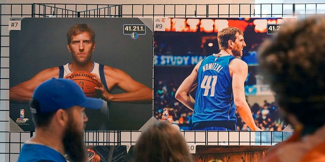 People stand in line to buy memorabilia of former Dallas Mavericks Dirk Nowitzki before an NBA basketball game between the Golden State Warriors and Dallas Mavericks in Dallas, 星期三, 一月. 5, 2022. The Mavericks are retiring Nowitzki's number in a ceremony after the game.