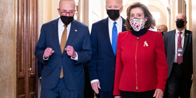 President Biden arrives with House Speaker Nancy Pelosi of California, and Senate Majority Leader Chuck Schumer of New  York, on his way to speak from Statuary Hall at the U.S. Capitol to mark the one year anniversary of the Jan. 6 riot at the Capitol by supporters loyal to then-President Donald Trump, Thursday, Jan. 6, 2022, in Washington. (Bill Clark/Pool via AP)