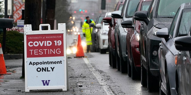 A line of cars stretching several blocks wait to pull into an appointment-only COVID-19 testing center, Thursday, Jan. 6, 2022, in Seattle. 