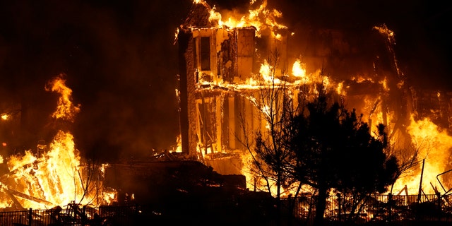 Homes burn as a wildfire rips through a development near Rock Creek Village, Dec. 30, 2021, near Broomfield, Colo. (AP Photo/David Zalubowski, File)