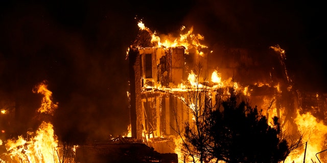Homes burn as a wildfire rips through a development near Rock Creek Village, Dec. 30, 2021, near Broomfield, Colo. (AP Photo/David Zalubowski, File)