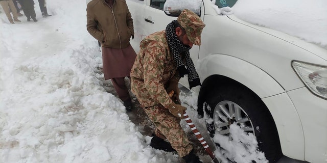 An army soldier takes part in a rescue operation in a heavy snowfall-hit area in Murree, some 28 miles (45 kilometers) north of the capital of Islamabad, Pakistan, Saturday, Jan. 8, 2022. (Inter Services Public Relations via AP)