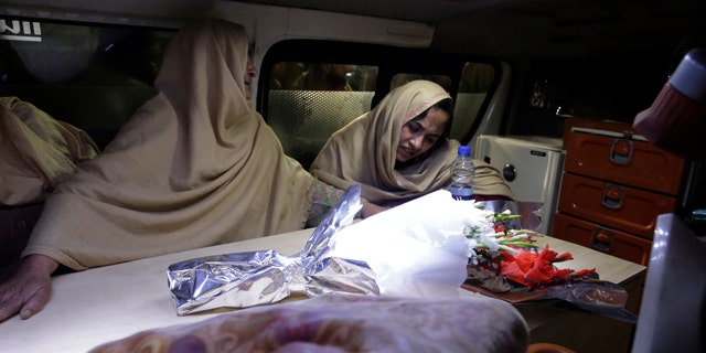 Women cry inside an ambulance after they lost their family members during a heavy snowfall-hit area in Murree, some 28 miles (45 kilometers) north of the capital of Islamabad, Pakistan, Saturday, Jan. 8, 2022. (AP Photo/Rahmat Gul)