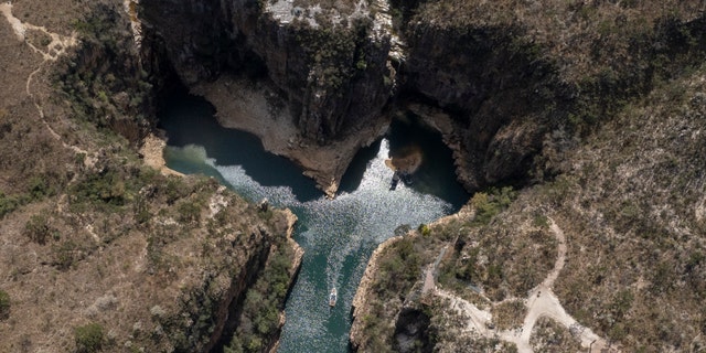 A tourist boat sails through a canyon in Furnas Lake, near Capitolio City, Brazil, September 2, 2021. (AP Photo / Andre Penner)