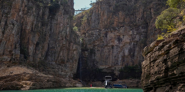A tourist boat navigates through a canyon in Furnas Lake, near Capitolio City, Brazil, Sept. 2, 2021. 