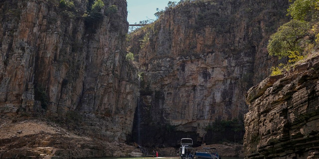 A tourist boat navigates through a canyon in Furnas Lake, near Capitolio City, Brazil, Sept. 2, 2021. 