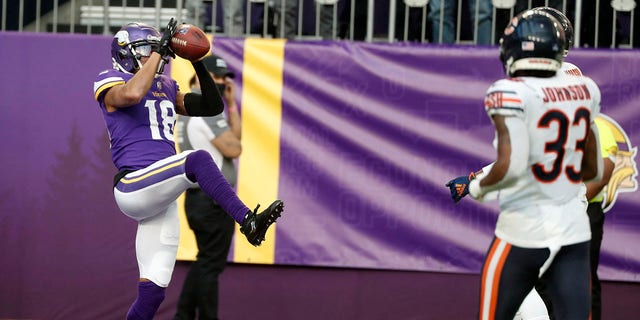 Minnesota Vikings wide receiver Justin Jefferson (18) catches a 45-yard touchdown pass ahead of Chicago Bears cornerback Jaylon Johnson (33) NFL 축구 경기의 후반부 동안, 일요일, 1 월. 9, 2022, 미니애폴리스에서.