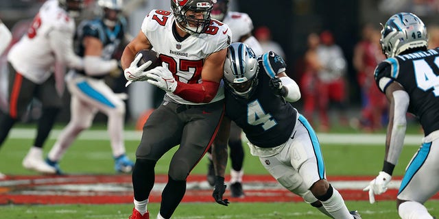 Tampa Bay Buccaneers tight end Rob Gronkowski (87) gets hit by Carolina Panthers middle linebacker Jermaine Carter (4) after a catch during the first half of an NFL football game Sunday, Jan. 9, 2022, in Tampa, Fla.