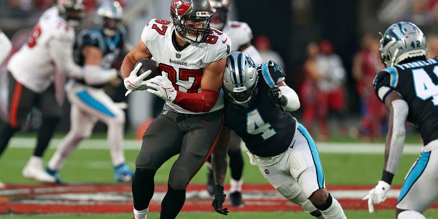 Tampa Bay Buccaneers tight end Rob Gronkowski (87) gets hit by Carolina Panthers middle linebacker Jermaine Carter (4) after a catch during the first half of an NFL football game Sunday, Jan. 9, 2022, in Tampa, Fla.