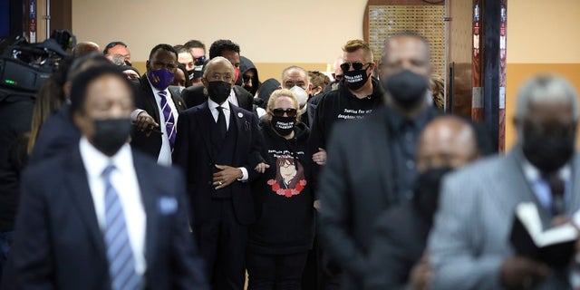 The Reverend Al Sharpton walks mother Soledad Peralto and father Juan Pablo Orellana into the funeral for 14-year-old Valentina Orellana Peralta, killed on Dec. 23, by a LAPD police officer's stray bullet while shopping with her mother, is readied for her funeral at the City of Refuge Church in Gardena, Calif., Monday, Jan. 10, 2022. (AP Photo/David Swanson)