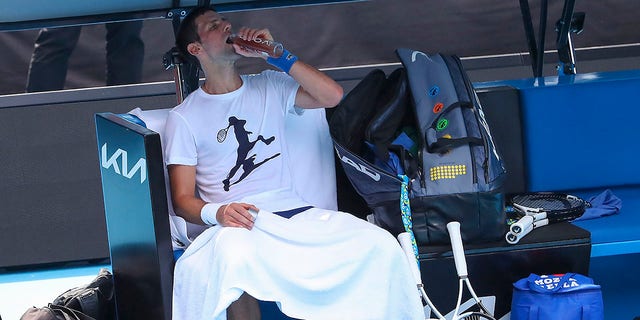 Defending champion Serbia's Novak Djokovic takes a drink during a practice session at the Rod Laver Arena ahead of the Australian Open at Melbourne Park in Melbourne, Australia, Tuesday, Jan. 11, 2022.