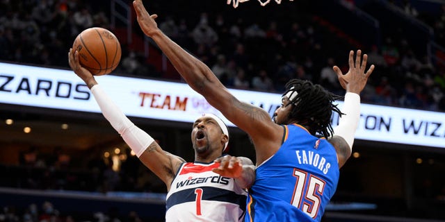 Oklahoma City Thunder center Derrick Favors fouls Wizards guard Kentavious Caldwell-Pope Tuesday, Jan. 11, 2022, in Washington.