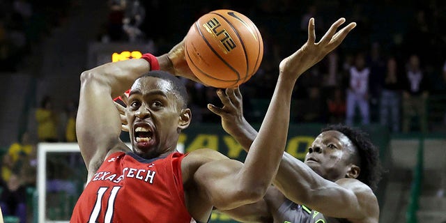 CORRECTS ID TO BAYLOR FORWARD JONATHAN TCHAMWA TCHATCHOUA, RIGHT - Texas Tech forward Bryson Williams, left,,  grabs a loose ball from Baylor forward Jonathan Tchamwa Tchatchoua during the second half of an NCAA college basketball game Tuesday, Jan. 11, 2022, in Waco, Texas.