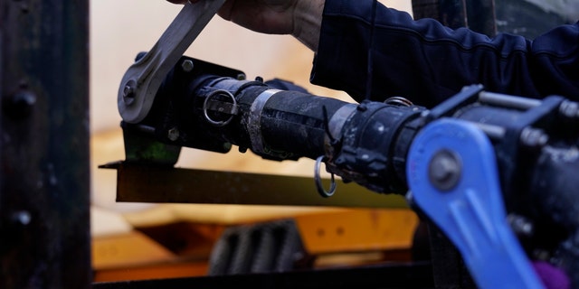 A Georgia Department of Transportation response member pulls a lever on a brine truck ahead of a winter storm at the GDOT's Maintenance Activities Unit location on Friday, Jan. 14, 2022, in Forest Park, Ga. (AP Photo/Brynn Anderson)