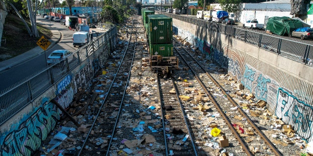 A train stops as shredded boxes and packages are seen at a section of the Union Pacific train tracks in downtown Los Angeles Friday, Jan. 14, 2022. (AP Photo/Ringo H.W. Chiu)