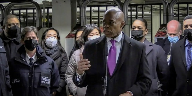 In this livestream frame grab from video provided by NYPD News, Mayor Eric Adams, foreground, with city law officials, speaks at a news conference inside a subway station after a woman was pushed to her death in front of a subway train at the Times Square station, Saturday, Jan. 15, 2022, in New York. 
