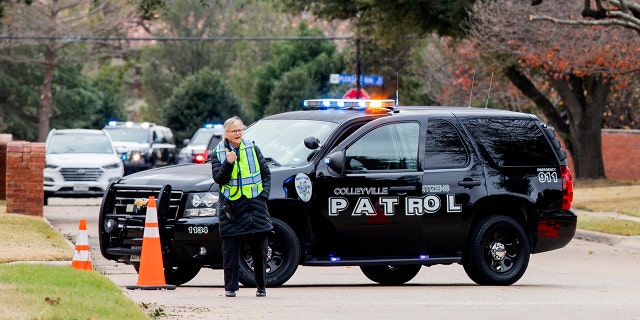 Law enforcement officials block a residential street near Congregation Beth Israel synagogue where a man took hostages during services on Saturday, Jan. 15, 2022, in Colleyville, Texas.