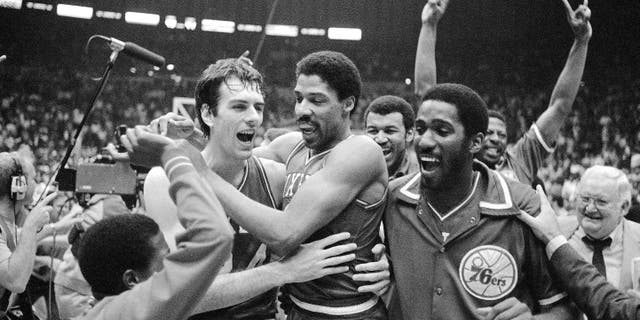 Philadelphia 76ers Bobby Jones, 左, embraces Julius Erving after the 76ers defeated the Los Angeles Lakers in four straight games to win the NBA Championship, 五月 31, 1983.