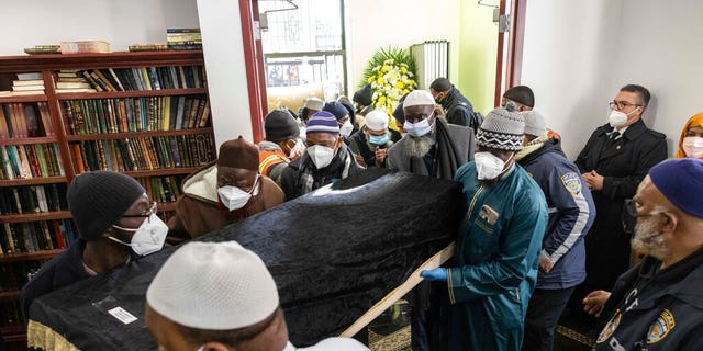 People bring in a casket during the funeral service for victims from the apartment building which suffered the city's deadliest fire in three decades, at the Islamic Cultural Center for the Bronx on Sunday, Jan. 16, 2022, in New York. 