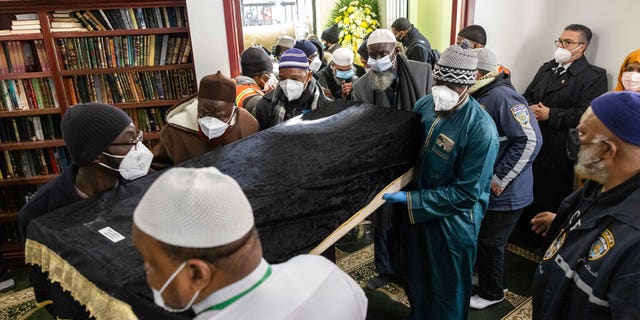 People bring in a casket during the funeral service for victims from the apartment building which suffered the city's deadliest fire in three decades, at the Islamic Cultural Center for the Bronx on Sunday, Jan. 16, 2022, in New York. 