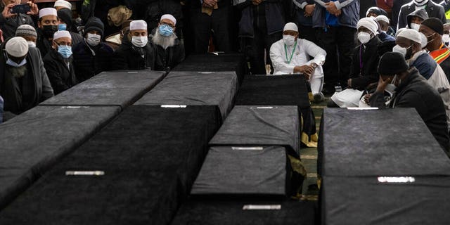 Caskets sit on the floor during the funeral service for victims from the apartment building which suffered the city's deadliest fire in three decades, at the Islamic Cultural Center for the Bronx on Sunday, Jan. 16, 2022, in New York.  