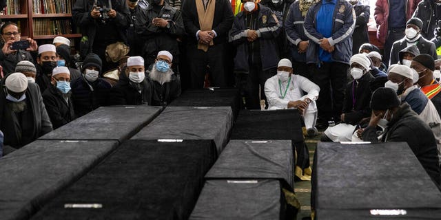 Caskets sit on the floor during the funeral service for victims from the apartment building which suffered the city's deadliest fire in three decades, at the Islamic Cultural Center for the Bronx on Sunday, Jan. 16, 2022, in New York.  