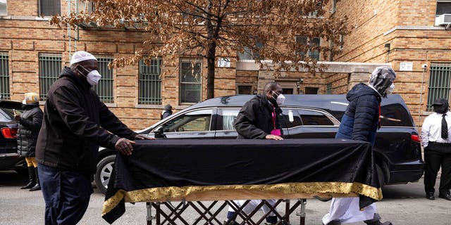 People move a casket to a hearse after the funeral service for victims from the apartment building which suffered the city's deadliest fire in three decades, at the Islamic Cultural Center for the Bronx on Sunday, Jan. 16, 2022, in New York.  