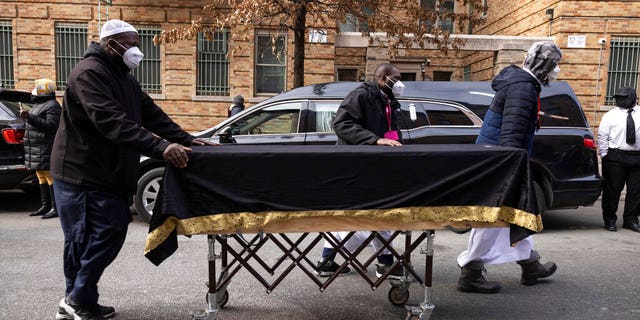 People move a casket to a hearse after the funeral service for victims from the apartment building which suffered the city's deadliest fire in three decades, at the Islamic Cultural Center for the Bronx on Sunday, Jan. 16, 2022, in New York.  