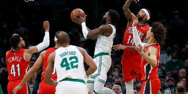 Boston Celtics guard Jaylen Brown (7) drives to the basket ahead of New Orleans Pelicans forward Brandon Ingram (14) during the first half of an NBA basketball game, Monday, Jan. 17, 2022, in Boston.