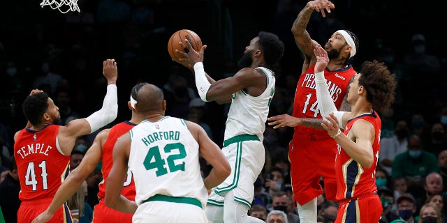 Boston Celtics guard Jaylen Brown (7) drives to the basket ahead of New Orleans Pelicans forward Brandon Ingram (14) during the first half of an NBA basketball game, 月曜, 1月. 17, 2022, ボストンで.