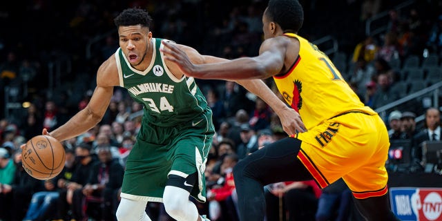 Milwaukee Bucks forward Giannis Antetokounmpo (34) dribbles past Atlanta Hawks forward Onyeka Okongwu (17) during the first half of an NBA basketball game Monday, ene. 17, 2022, en Atlanta.