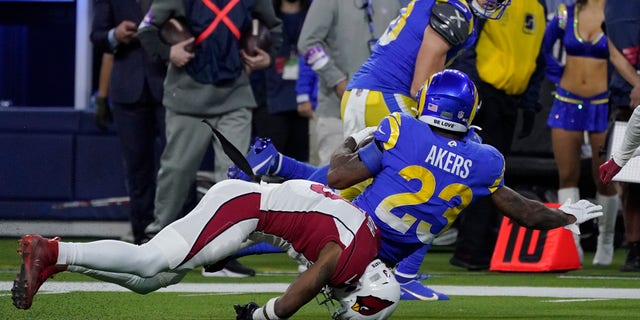 Arizona Cardinals safety Budda Baker, bottom, falls forward after tackling Los Angeles Rams running back Cam Akers (23) during the second half of an NFL wild-card playoff football game in Inglewood, Calif., lunes, ene. 17, 2022. 