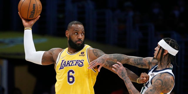 Los Angeles Lakers forward LeBron James (6) is defended by Utah Jazz guard Jordan Clarkson, right, during the first half in Los Angeles on Jan. 17, 2022.