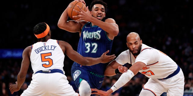 Minnesota Timberwolves center Karl-Anthony Towns (32) drives to the basket against New York Knicks guard Immanuel Quickley (5) and New York Knicks center Taj Gibson (67) during the first half of an NBA basketball game, Tuesday, Jan. 18, 2022 in New York.