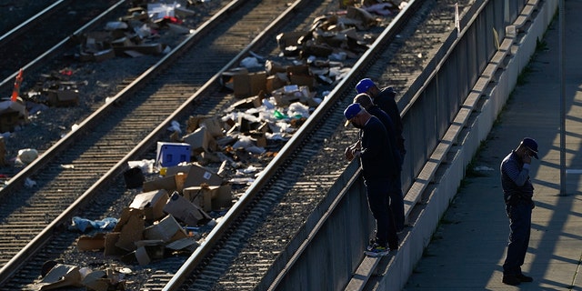 Men look over a railing at a Union Pacific railroad site on Thursday, Jan. 20, 2022, in Los Angeles.
