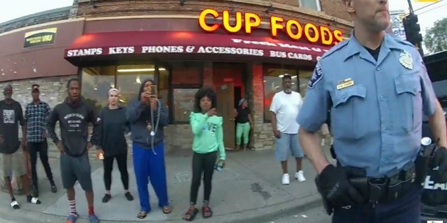 文件 - In this image from police body camera video former Minneapolis police Officer Derek Chauvin stands outside Cup Foods in Minneapolis, 在5月 25, 2020, with a crowd of onlookers behind him. 