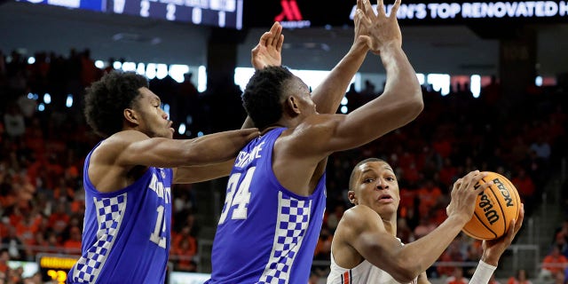 Auburn forward Jabari Smith (10) looks for an open shot as Kentucky forward Keion Brooks Jr. (12) and forward Oscar Tshiebwe (34) defends during the second half of an NCAA college basketball game Saturday, Jan. 22, 2022, in Auburn, Ala.