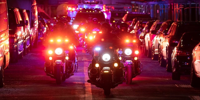 NYPD officers in motorcycles lead an ambulance carrying Officer Wilbert Mora as he is transferred from Harlem Hospital to NYU Langone hospital on Sunday, Jan.. 23, 2022 in the Harlem neighborhood of New York.