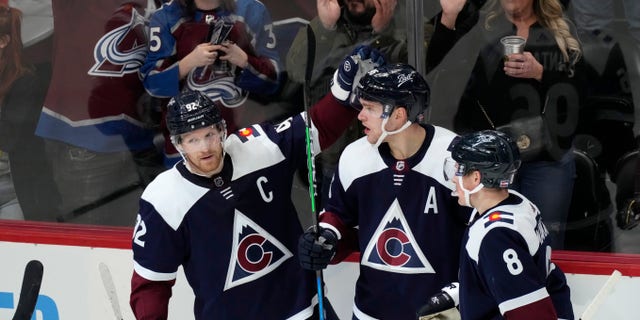 Colorado Avalanche right wing Mikko Rantanen, centrar, is congratulated after scoring a goal by left wing Gabriel Landeskog, izquierda, and defenseman Cale Makar in the third period of an NHL hockey game against the Chicago Blackhawks Monday, ene. 24, 2022, en Denver. The Avalanche won 2-0.