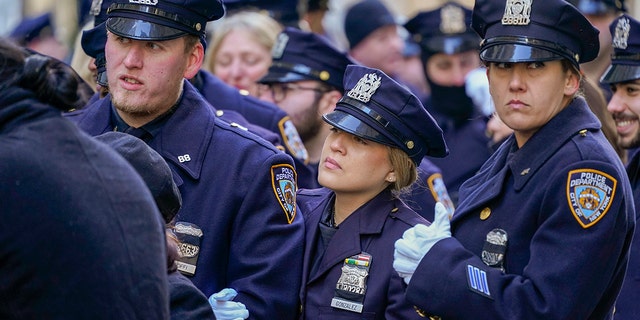 Police officers stand in line outside St. Patricks Cathedral to pay their respects during the wake of New York City Police Officer Jason Rivera, Thursday, Jan. 27, 2022, in New York.  (AP Photo/Mary Altaffer)