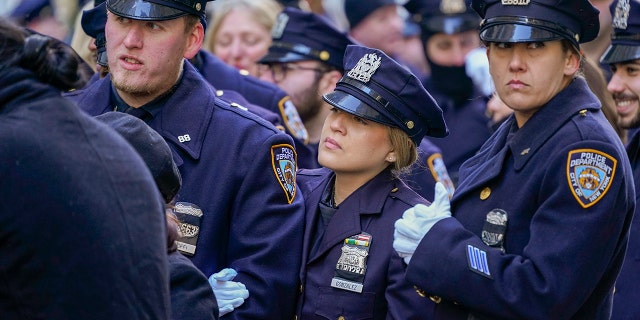 Police officers stand in line outside St. Patricks Cathedral to pay their respects during the wake of New York City Police Officer Jason Rivera, Thursday, Jan. 27, 2022, in New York.  (AP Photo/Mary Altaffer)