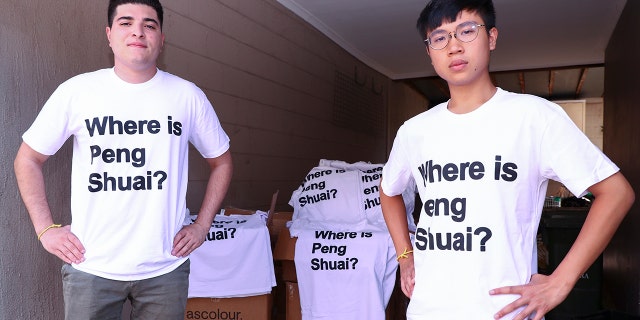 Drew Pavlou, left, and Max Mok show some of the 1,000 shirts they plan to hand out to patrons ahead of Saturday's women's singles final at the Australian Open tennis championships in Melbourne, Australia, Friday, Jan. 28, 2022. As he was being ejected for wearing a shirt with a Where is Peng Shuai? slogan, Max Mok saw an opportunity to amplify the message at the Australian Open.