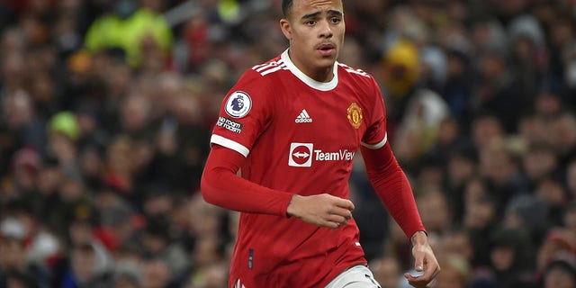 FILE- Manchester United's Mason Greenwood runs during the English Premier League soccer match between Manchester United and Burnley at Old Trafford in Manchester, England, Thursday, Dec. 30, 2021. Manchester United says forward Mason Greenwood will not play or practice with the club until further notice after being accused of sexual assault by a woman, with police also looking into the incident. The statement from the Premier League club was issued on Sunday, Jan. 30, 2022 in response to allegations being posted within videos, photographs and an audio recording that are no longer visible on a woman’s Instagram account.