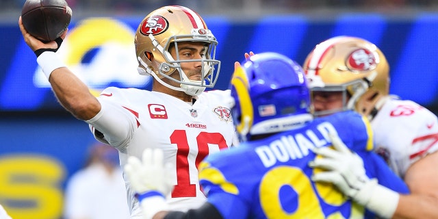 San Francisco 49ers quarterback Jimmy Garopolo (10) throws a pass under pressure from Aaron Donald (99) of the Los Angeles Rams during the NFL game between the San Francisco 49ers and the Los Angeles Rams on January 9, 2022 at Sophie Stadium in Inglewood. , CA