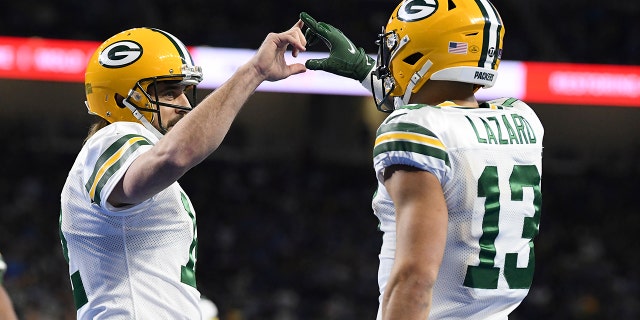 El receptor abierto de los Green Bay Packers, Allen Lazard, a la derecha, es felicitado por el mariscal de campo Aaron Rodgers después de pasar 29 yardas para un touchdown durante la primera mitad de un partido de fútbol americano de la NFL contra los Detroit Lions, el domingo 9 de enero de 2022, en Detroit.