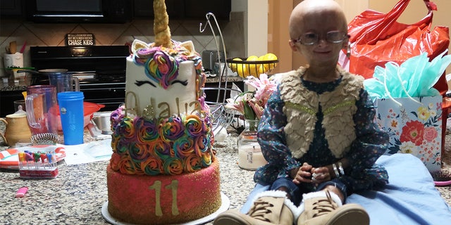 YouTube superstar Adalia Rose sits next to her 11th birthday cake at home on December 10, 2017, in Austin, Texas. The 11-year-old diva' was an Internet superstar and built up a vast following on social media - despite suffering from a super-rare ageing condition.
