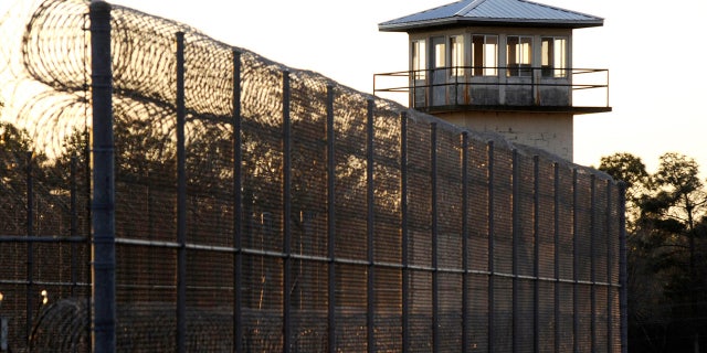 The sun sets behind Holman Prison in Atmore, Alabama, on Thursday, Jan., 27, 2022, as the U.S. Supreme Court considered whether to allow the execution of death row inmate Matthew Reeves, convicted of killing a man during a robbery in 1996.