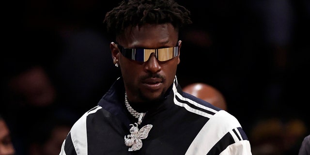 Former Tampa Bay Buccaneers wide receiver Antonio Brown arrives courtside during the second half of an NBA basketball game between the Memphis Grizzlies and the Brooklyn Nets Jan. 3, 2022, in New York.