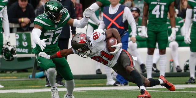 New York Jets' Bryce Hall tackles Tampa Bay Buccaneers' Antonio Brown Sunday, Jan. 2, 2022, in East Rutherford, New Jersey.