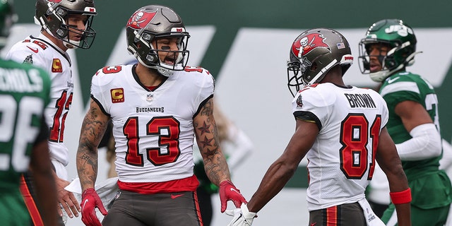 Jan 2, 2022; East Rutherford, New Jersey, USA; Tampa Bay Buccaneers wide receiver Mike Evans (13) slaps hands with wide receiver Antonio Brown (81) after a touchdown reception during the first half against the New York Jets at MetLife Stadium.